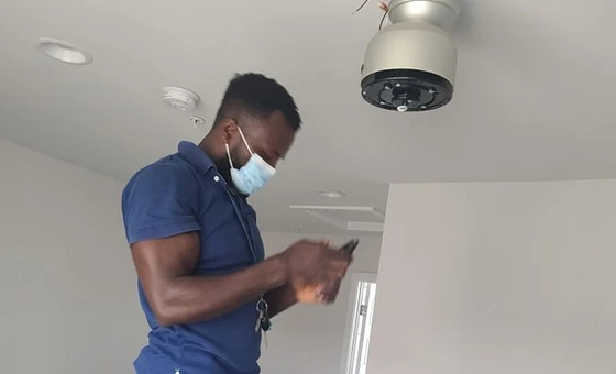 Electrician in Fairfax, VA repairing a light fixture, showing professional light fixture repair services.