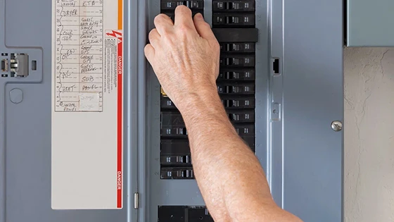 Electrician troubleshooting a breaker panel for repair in Laurel, MD.
