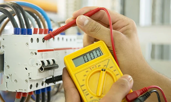 Electrician inspecting electrical wiring in Laurel MD with a multimeter, representing fixture wiring and electrical safety services.